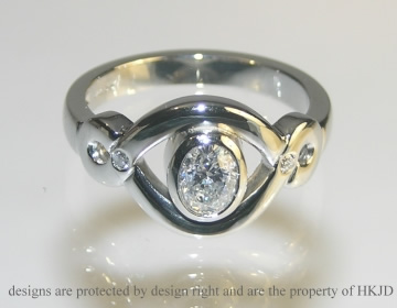 Bespoke platinum infinity symbol inspired oval diamond engagement ring.