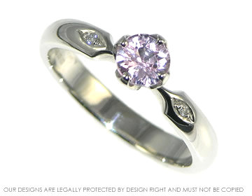 A platinum pink sapphire and diamond flower inspired engagement ring.