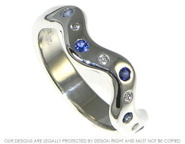 18ct white gold ripple shaped eternity ring with blue sapphires scatter set across the band