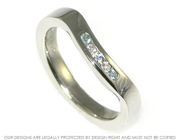 Bespoke shaped platinum wedding ring with white and heat-treated blue diamonds