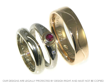 Pair of bespoke 18ct gold wedding rings with engraved waves.