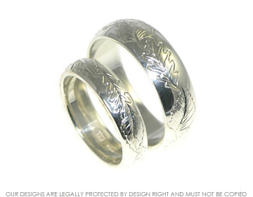 A pair of Bespoke sterling silver wedding rings with engraved detailing.