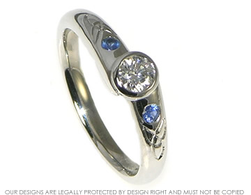 Platinum engagement ring with diamond and sapphires.