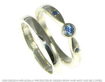 9ct white gold wedding band with a 1.5mm grain set blue sapphire set on the inside.