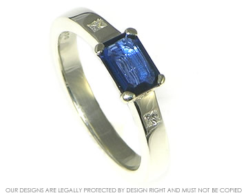 White gold deep blue sapphire emerald cut ring with side diamonds