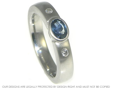 Platinum engagement ring with oval blue sapphire and two diamonds. 