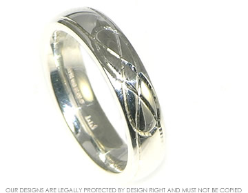 A 5mm Silver wedding band with engraved knotwork detail and a polished finish. 