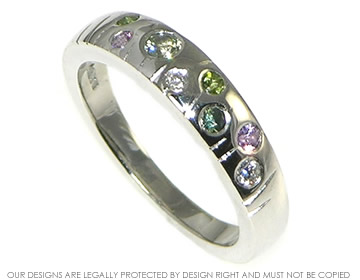 Bespoke meadow inspired eternity ring with diamonds and green and lilac sapphires.