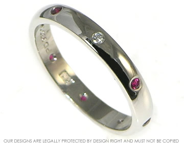 Palladium eternity ring with seven 1.75mm 0.20ct rubies and one 1.75 0.02ct H SI diamond invisibly set and evenly spaced all the way round.