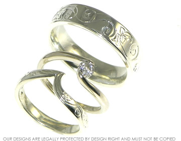 A pair of 9ct white gold wedding bands with ivy engraved detail.