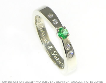 Bespoke 9ct white gold eternity ring with an emerald and four diamonds.