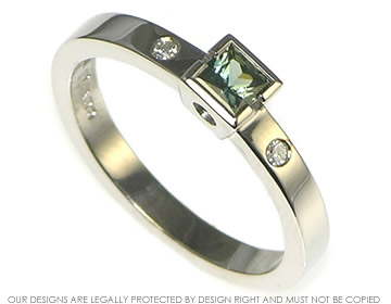 A palladium green sapphire and diamond engagement ring.