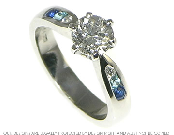 Diamond engagement ring with graduating blue shoulder stones. 