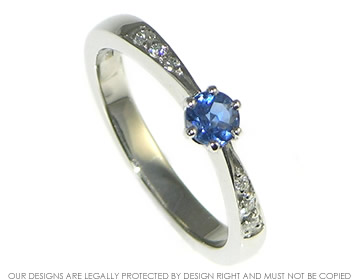 Bespoke platinum engagement ring with blue sapphire and diamond.