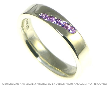 A 9ct white gold eternity ring with 5 purple/pink sapphires set diagonally