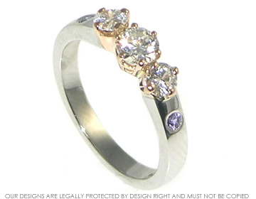 Platinum engagement ring with three central brilliant cut H SI diamonds and invisibly set lilac sapphires.