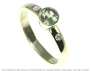 White gold engagement ring with a 0.54ct brilliant cut green sapphire and two diamonds in the shoulders