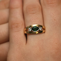contemporary mixed metal engagement ring with deep green tsavorite and diamonds