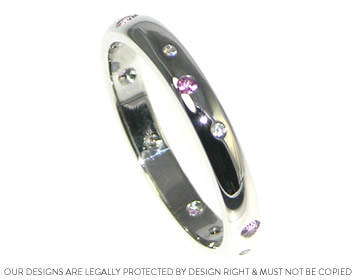 An eternity ring scatter set with diamonds and pink sapphires