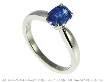 Platinum engagement ring with a cushion cut blue sapphire