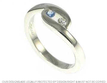 Twist style engagement ring with a diamond and sapphire