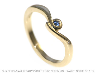 A delicate twist engagement ring with a sapphire and diamond