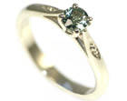 a classically styled engagement ring with a green sapphire