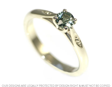 A classically styled engagement ring with a green sapphire