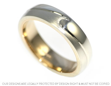 A handmade white and yellow gold wedding ring with engraving