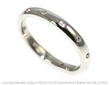 A bespoke palladium diamond and pink sapphire eternity ring 