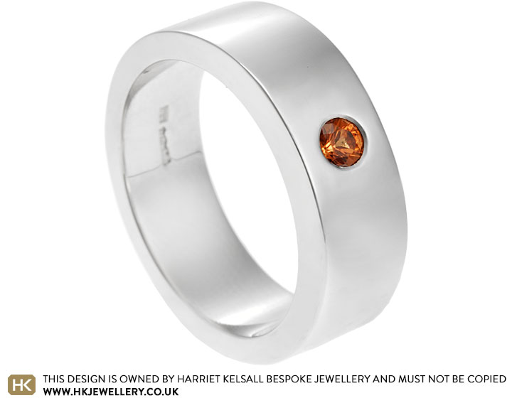 Laurence's platinum wedding ring with an orange sapphire