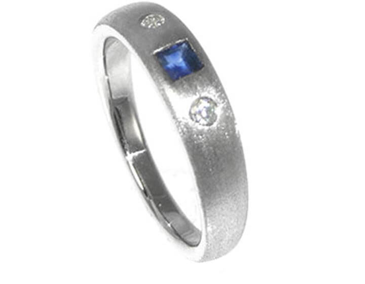 Platinum eternity ring with a central sapphire  and two diamonds