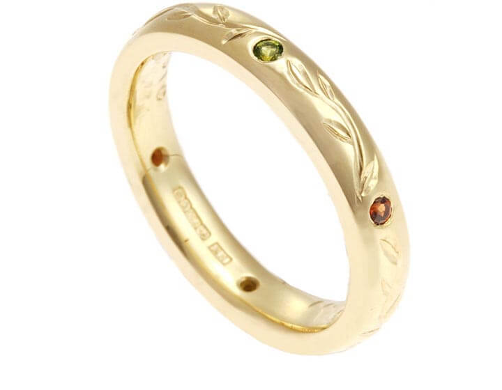 Rebecca's 18 carat yellow gold wedding ring with leaf engraving and coloured gemstones